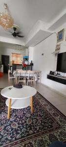 een woonkamer met een witte tafel en een tapijt bij Rosnah Homestay in Kampong Ayer Resam