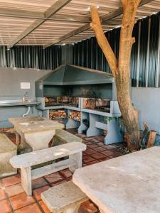 una cocina con mesas de picnic y un árbol. en Islas de Arena en Colón