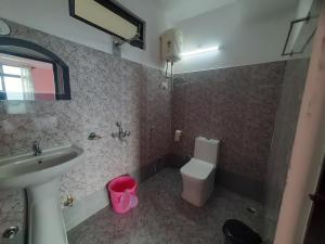 uma casa de banho com um lavatório e um WC em Bubble Beds em Darjeeling