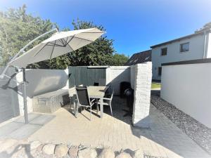 a patio with an umbrella and a table and chairs at WILMA holiday home directly at the Baltic Sea in Zierow