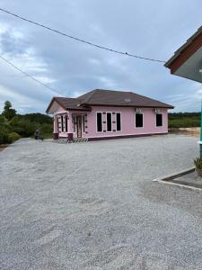 a pink house sitting on top of a driveway at Homestay Armand Pengkalan Balak Melaka in Masjid Tanah