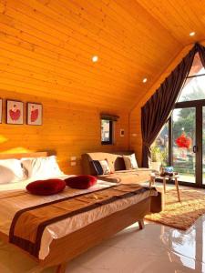 two large beds in a bedroom with wooden walls at Hoàng Yến Garden Ba Vì in Hanoi