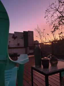 una mesa en una terraza con una puesta de sol en el fondo en Loft Vintage en Tandil