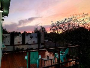 2 Stühle und ein Tisch auf einer Terrasse mit Sonnenuntergang in der Unterkunft Loft Vintage in Tandil