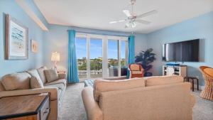 a living room with two couches and a tv at Laketown Wharf #317 by Nautical Properties in Panama City Beach