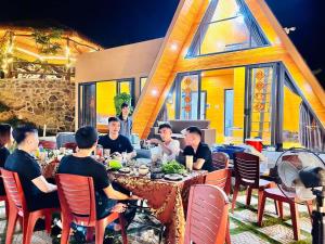 a group of people sitting at a table in a restaurant at Hoàng Yến Garden Ba Vì in Hanoi