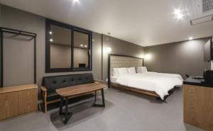 a bedroom with a bed and a table and a tv at Forest 701 hotel in Changwon