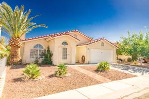 a house with a palm tree in front of it at Beautiful Las Vegas Home in Las Vegas