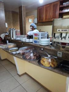 a man in a kitchen preparing food on a counter at Pousada do Turista in Fortaleza