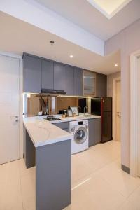 a kitchen with a washer and dryer in it at Amalea at Benson Pakuwon Mall in Surabaya