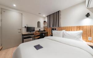 - une chambre avec un lit et un bureau avec un ordinateur dans l'établissement Just Stay Hotel, à Séoul