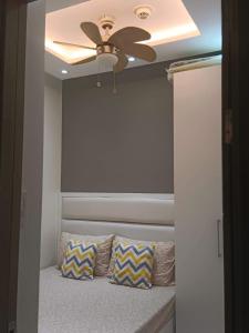 マニラにあるFame Residences T1 Family Suite 1507のベッドルーム1室(天井ファン、枕付きベッド1台付)