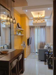 Fame Residences T1 Family Suite 1507 في مانيلا: مطبخ وغرفة معيشة بجدران صفراء