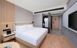 Un pat sau paturi într-o cameră la 义乌曼卡兰酒店国际商贸城店Yiwu kaiding Hotel