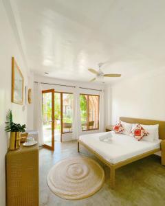 una camera con letto e ventilatore a soffitto di Tropical Temple Siargao Resort a General Luna