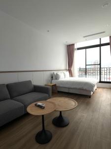 a living room with a couch and a bed and a table at 鄢室民宿 in Hualien City