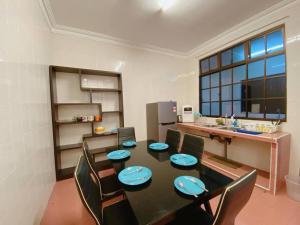 a dining room with a table and chairs and a kitchen at C01 Budget Homestay in Tmn Rinting in Masai