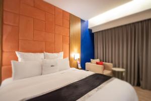 168 Motel-Hsinchu في مدينة هسينشو: غرفة نوم بسرير كبير وكرسي