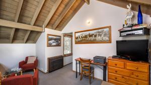 a living room with a television and a table and chairs at Kunama in Dinner Plain