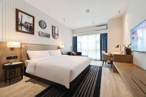 ein Hotelzimmer mit einem Bett und einem Flachbild-TV in der Unterkunft Livetour Hotel Luogang Science City Guangzhou in Guangzhou