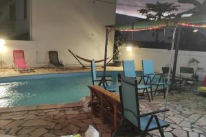 a swimming pool with chairs and a table next to a swimming pool at Maison de Jo in Fleurimont