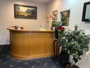 a reception desk in a waiting room with flowers at Fairview Inn in Simcoe