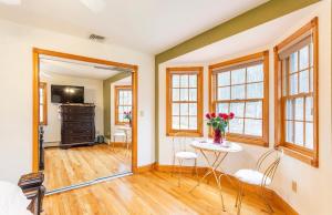 een woonkamer met een tafel, stoelen en ramen bij Villa Verde B&B, Greenwood Lake, NY in Monroe