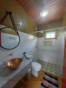 a bathroom with a bowl sink and a toilet at Chalés Vila das Cachoeiras in Diamantina