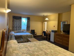 a hotel room with two beds and a television at Fairview Inn in Simcoe
