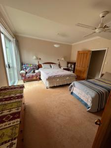 a bedroom with two beds and a ceiling fan at Tamaterau Seaview House in Whangarei in Whangarei