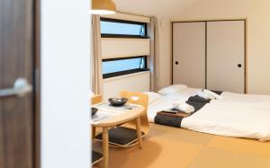 Cette petite chambre comprend deux lits et une table. dans l'établissement HANASTAY花渓居 · 梨（NASHI), à Osaka