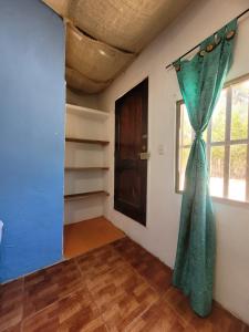 Tolu paradise 101 في San Silvestre: غرفة بها ستارة زرقاء ونافذة