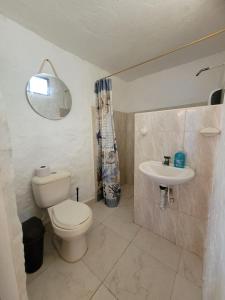 a bathroom with a toilet and a sink at Tolu paradise 101 in San Silvestre