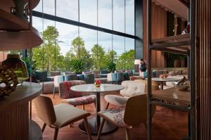 峇六拜的住宿－槟城国际会展中心阿玛瑞酒店，客房设有桌椅和大窗户。