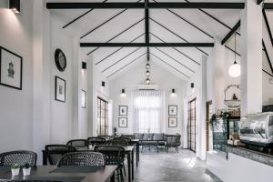 a restaurant with tables and chairs in a room at Palin Family Cottage in Chiang Rai