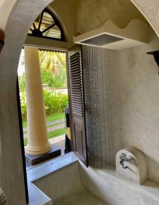 baño con ducha con lavabo y ventana en Pedlar's Manor, en Talpe