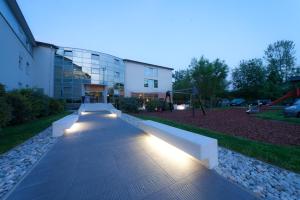 a building with a bench in front of a building with lights at Bit Center Hotel in Ljubljana