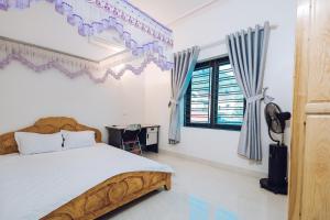 um quarto com uma cama, uma secretária e uma janela em Villa Habit 3br Center Mộc Châu em Mộc Châu