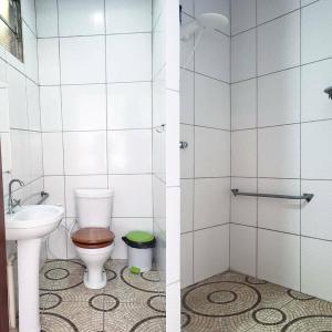 two pictures of a bathroom with a toilet and a sink at Pousada Boto in Salvaterra