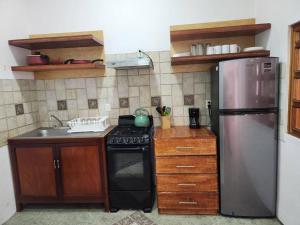 瓦哈卡德華雷斯的住宿－Casa Orestes - Hermosa casa cerca del Centro de Oaxaca，厨房配有不锈钢冰箱和炉灶。