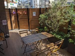 een patio met een houten hek en een houten tafel en stoelen bij Hostel JIN - Weekly Appartment in Osaka in Osaka