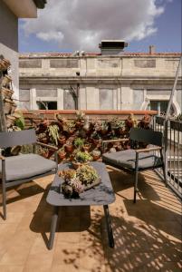 un balcón con un montón de macetas en un edificio en Tetti & Chiese - Authentic Sicilian Rooftop, en Catania