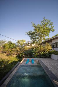 a swimming pool with two blue chairs in a backyard at Vista Loma Estate in San Isidro