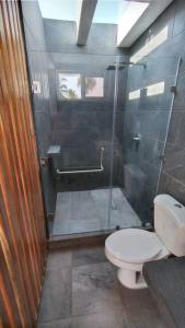 a bathroom with a toilet and a glass shower at Hermosa Casa de Playa in Escuintla