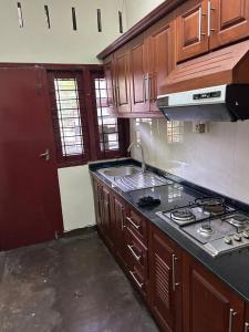 a kitchen with wooden cabinets and a stove top oven at MercuryFM 104 House Colombo 8 - Mangala Road 3-1 in Colombo
