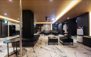 un salón con vestíbulo con mesas y sillas en Shinchon Wol Hotel en Seúl