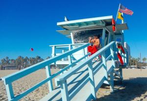 a lifeguard tower on the beach with two people at Casa Playa - Modern, Stylish, Spacious, Gated Entry, Rooftop Pool - BEST LOCATION - 4 BLKS to Ocean Avenue in Los Angeles
