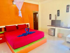 a bedroom with a red bed with a blue ribbon on it at Da Kanda Villa Beach Resort in Thong Sala