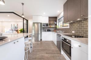 a kitchen with white cabinets and a counter top at Gunsynd Studio Apartment in Scone