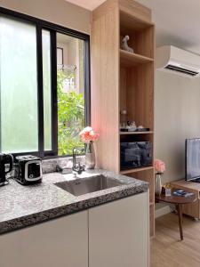 Diamond Resort by I Am Home في شاطئ بانغ تاو: مطبخ مع حوض ونافذة
